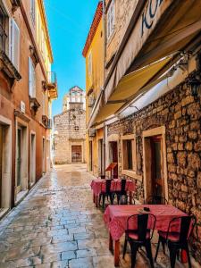 an alley with tables and chairs on a street at Sea View Studio Apartment in Zadar