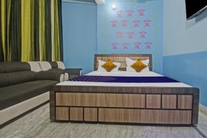 SPOT ON Hotel Rj14 في جايبور: غرفة نوم بسرير واريكة
