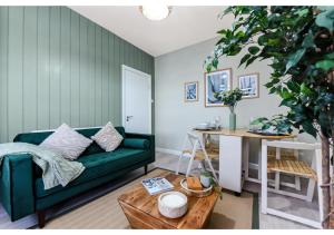 a living room with a green couch and a table at GREAT 4BR House in London