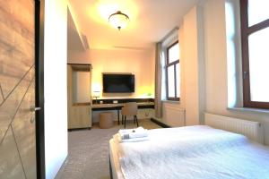 a bedroom with a bed and a desk with a television at Am Fluss Saale in Weißenfels