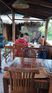 2 personnes assises à une table dans un restaurant dans l'établissement Dira Bungalows, à Tetebatu