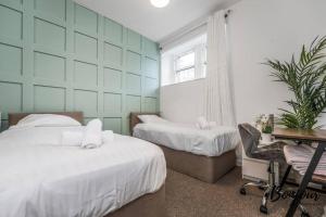 a bedroom with two beds and a desk and a chair at Cadet Suite - Cosy & Central-Grassmarket, Newly decorated! in Edinburgh