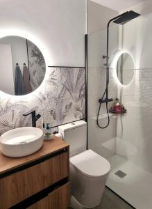 e bagno con servizi igienici, lavandino e doccia. di Luxury Penthouse Valentin with jacuzzi a Corralejo