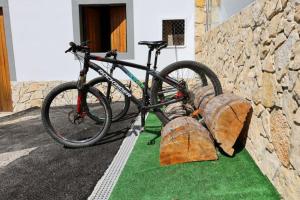 una bicicletta parcheggiata accanto a un muro di pietra di Da Serra guesthouse a Porto de Mós