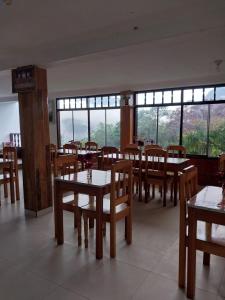 a dining room with tables and chairs and windows at Monte Gocta in Valera