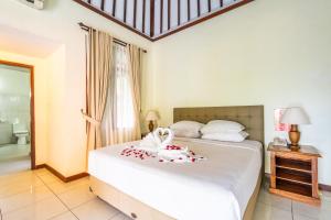 Postel nebo postele na pokoji v ubytování Taman Surgawi Resort & Spa