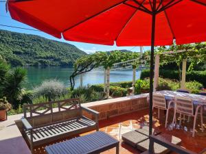 a patio with a red umbrella and a table and chairs at Apartments by the sea Broce, Peljesac - 13182 in Ston
