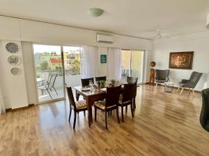 a dining room and living room with a table and chairs at Shiny Blue Apartment in Limassol