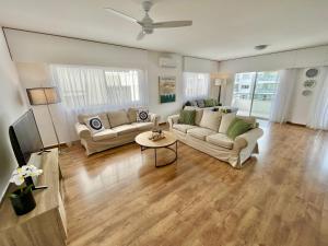 a living room with two couches and a tv at Shiny Blue Apartment in Limassol