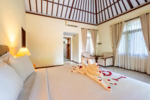 a hotel room with a bed with a towel on it at Taman Surgawi Resort & Spa in Jasri