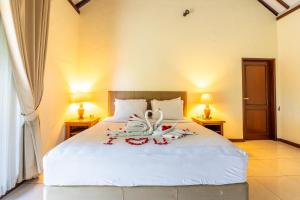 Postel nebo postele na pokoji v ubytování Taman Surgawi Resort & Spa