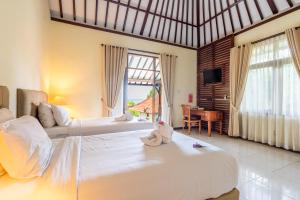 Postel nebo postele na pokoji v ubytování Taman Surgawi Resort & Spa