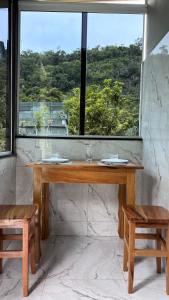 una mesa de madera en una habitación con una ventana grande en Recanto dos Ipês, en Viana