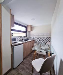 a kitchen with a glass table and white chairs at Apart10 "Capture Old Tbilisi Spirit" in Tbilisi City