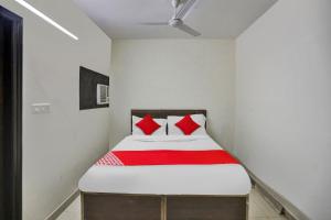 a bedroom with a bed with red pillows at Flagship Raj Pavilion Near Lotus Temple in New Delhi