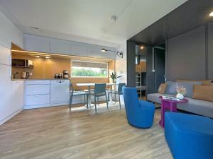 a kitchen and a living room with a table and chairs at Holiday Village Seeblick - tiny house with lake view in Neunburg vorm Wald