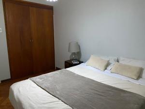 ein Schlafzimmer mit einem großen Bett und einem Holzschrank in der Unterkunft BBCasita Las Condes in Santiago