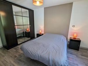 a bedroom with a bed and a large mirror at Gîte familial à Cornimont avec Wifi et parking - FR-1-589-84 in Cornimont