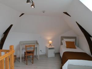 1 dormitorio con cama, escritorio y silla en Gîte Sainte-Suzanne-et-Chammes, 4 pièces, 6 personnes - FR-1-600-151, en Sainte-Suzanne