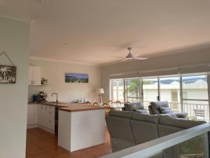 een woonkamer met een bank en een keuken bij Beaches 9 in Merimbula