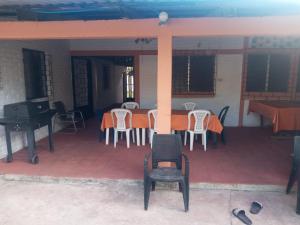 a porch with a table and chairs and a piano at Rancho santa cecilia in Sonsonate