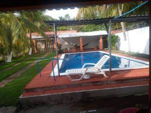a swimming pool with two lounge chairs on a patio at Rancho santa cecilia in Sonsonate