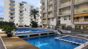 a swimming pool in front of a building at Apartments Novelty in Salou