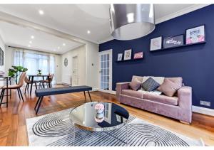 una sala de estar con un sofá y una mesa en Homey and Pleasant 3BD, en Londres