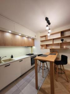 a kitchen with a wooden table and chairs in it at KS M Centrum in Warsaw
