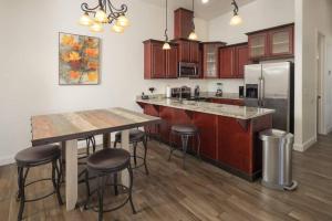 a kitchen with wooden cabinets and a table with bar stools at Luxury Downtown Moab Rental - La Dolce Vita Villa #1 in Moab +16 photos
