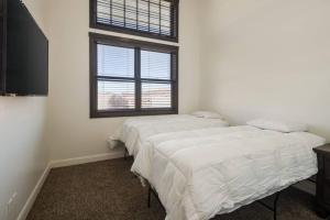 two beds in a room with a window at Luxury Downtown Moab Rental - La Dolce Vita Villa #1 in Moab