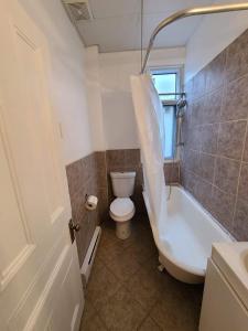 a bathroom with a tub and a toilet and a sink at 400$/week // Room B // Full Kitchen in Montréal