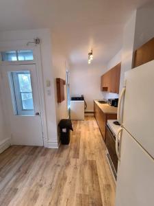 a kitchen with a white refrigerator and wooden floors at 400$/week // Room B // Full Kitchen in Montréal