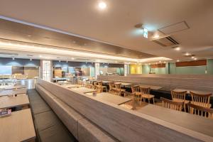 a restaurant with a long counter and tables and chairs at Hotel Angel Grandia Echigo Nakazato in Yuzawa