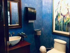 La salle de bains bleue est pourvue d'un lavabo et de toilettes. dans l'établissement Hotel Art Gallery Casona de los Milagros, à Colima
