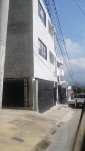 ein weißes Gebäude mit einem Tor neben einer Straße in der Unterkunft Apto en cucuta trapiches cerca a la Toyota in Villa del Rosario