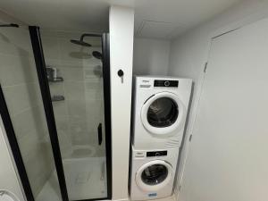 a washer and dryer in a small bathroom at Beautiful and cozy new condo in downtown in Montreal