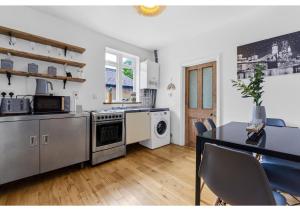 a kitchen with a table and a dining room at Handsome Family Home Peaceful, Next to Park in London