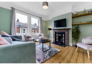 ein Wohnzimmer mit einem Sofa und einem Kamin in der Unterkunft Handsome Family Home Peaceful, Next to Park in London