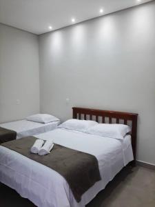 2 letti in una camera da letto con 2 asciugamani di Pousada Lobo Guará a São João Batista do Glória