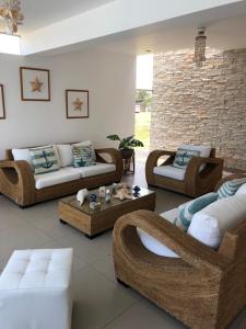 una sala de estar con sofás, mesas y una pared de ladrillo. en Casa de Playa Laguna Mar- Bujama km 89, en Asia