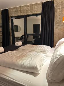 um quarto com uma grande cama branca e uma janela em Seljavellir Guesthouse em Höfn