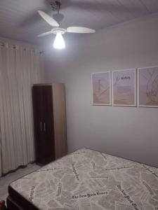sypialnia z łóżkiem i wentylatorem sufitowym w obiekcie casa aconchegante em Ubatuba w mieście São Francisco do Sul
