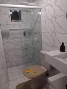 W łazience znajduje się prysznic, toaleta i umywalka. w obiekcie casa aconchegante em Ubatuba w mieście São Francisco do Sul