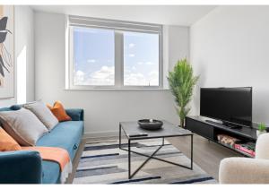 uma sala de estar com um sofá azul e uma televisão em Beckenham Beauty: Modern 1-Bedroom Abode em Beckenham