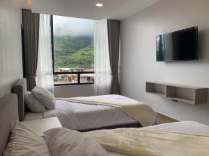 a hotel room with two beds and a television at LAS TOLAS HOTEL-RESTAURANTE in Pallatanga