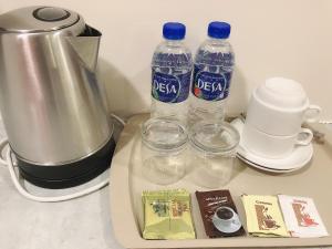 two bottles of water sitting on a tray next to a blender at GPI HOTEL Bentong in Bentong