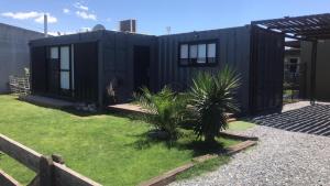 una casa modular negra con un patio con una casa en Casa container con pileta a 4 cuadras de la playa en Quequén