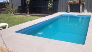 una piscina de agua azul en un patio en Casa container con pileta a 4 cuadras de la playa en Quequén
