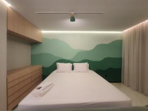 a bedroom with a bed with a mountain mural on the wall at Theotokos Flats Apart-hotel in Piumhi